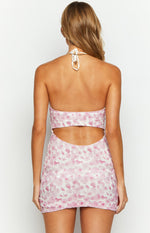 Back view of the pink lace mini dress showing the halter neck tie and open waist cutout