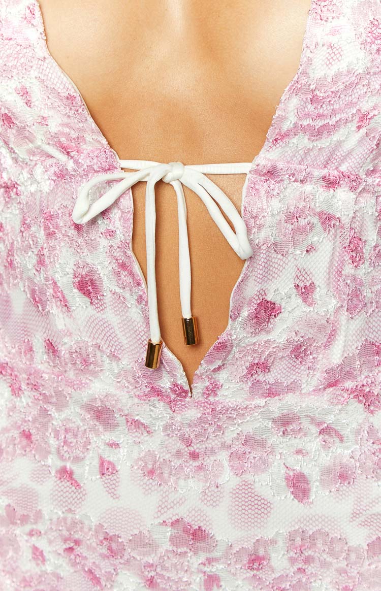 Close-up of the pink and white lace V-neck with white drawstring ties and gold toggles on a mini dress