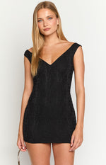 Off-shoulder V-neckline and short cap sleeves of a black mini dress with a subtle textured pattern