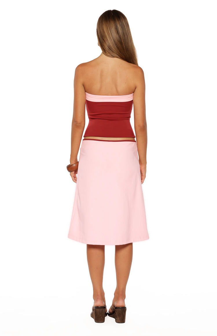 Rear view of a light pink A-line midi skirt with a smooth, flowing drape