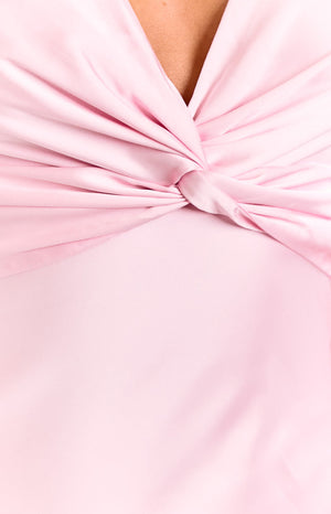 Model wears a light pink v-neck maxi dress. This romantic formal dress features a gathered bust and a flowy A-line skirt. A beautiful option for a wedding guest or special occasion.