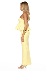 Side profile of a yellow crepe strapless top with a fitted bodice and a ruffled peplum waist