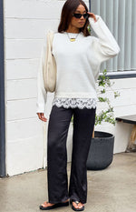 Black satin straight leg pants showing the full length and relaxed drape