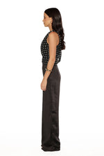 Side view of the black satin straight leg pants, showing the smooth fabric and relaxed, flowing fit