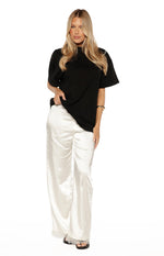 Full length view of ivory satin straight leg pants with delicate lace trim at the hem
