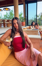 Light pink midi skirt with a side tie detail, showing its relaxed drape while seated