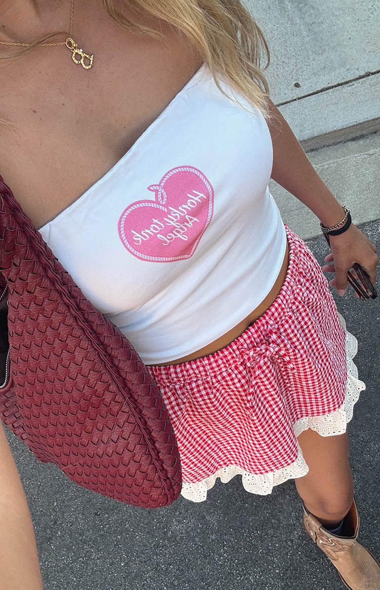 Top-down view of a red gingham mini skirt with an elasticated drawstring waist and white lace trim