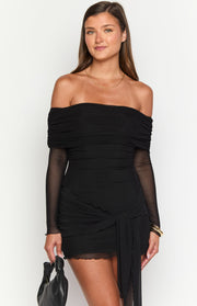 Front view of a black off-shoulder mini dress with ruched bodice, sheer long sleeves, and draped skirt detail