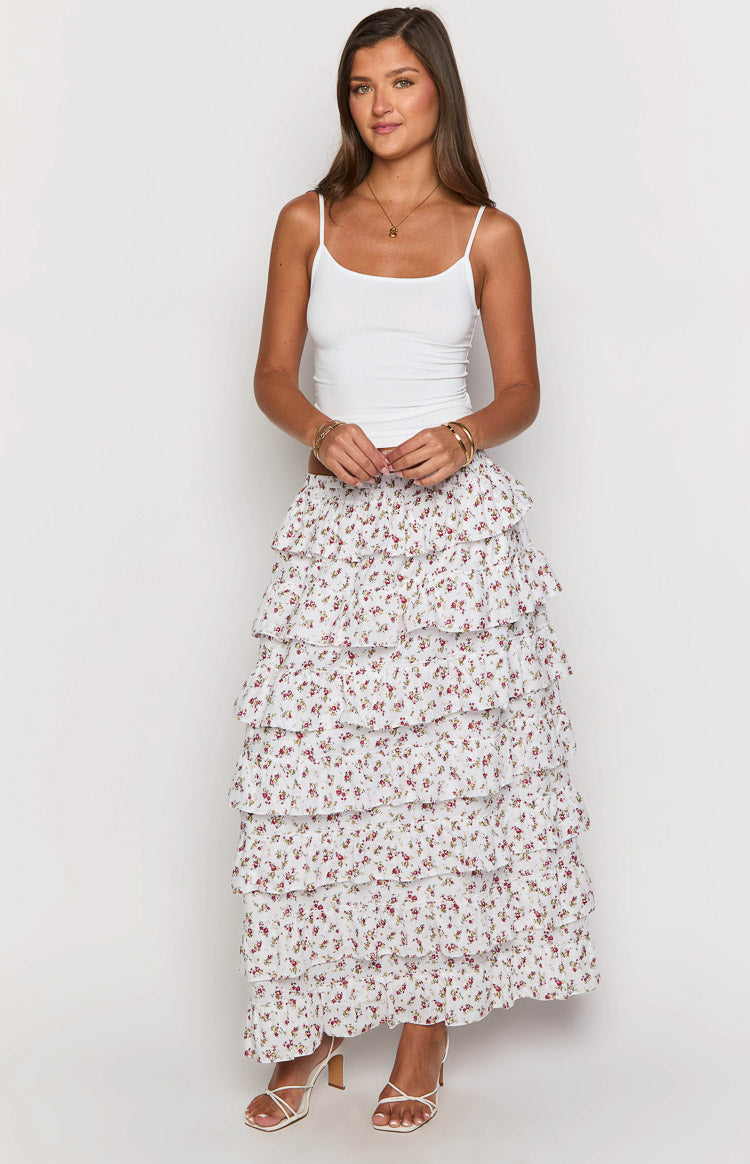 Front view of a white maxi skirt with small red and green floral print and five tiers of cascading ruffles