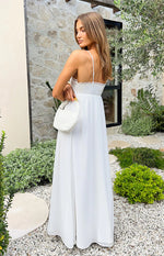 Side view of a white satin maxi dress with thin spaghetti straps, lace trim bust, and a flowing empire waist