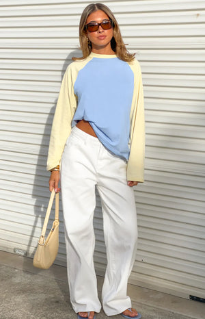 Front view of a blue and yellow contrast raglan sleeve top with a relaxed fit and slightly cropped front