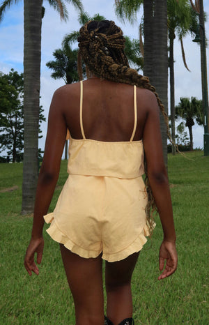Rear view of a petal yellow crop top with thin spaghetti straps and a gathered elasticated back