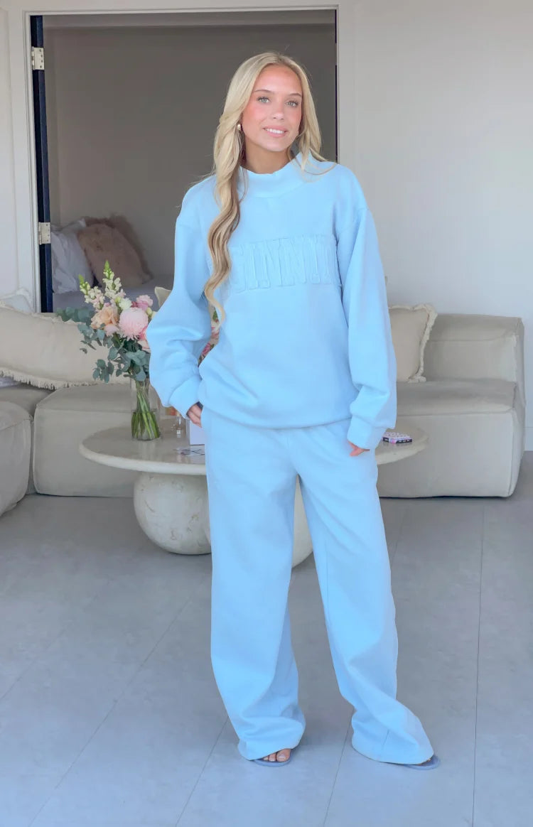 Front view of light blue mid-rise slouch fit trackpants with wide, relaxed legs