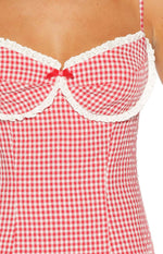 Close-up of the red gingham mini dress bodice featuring a sweetheart neckline with white eyelet lace trim and a small red bow