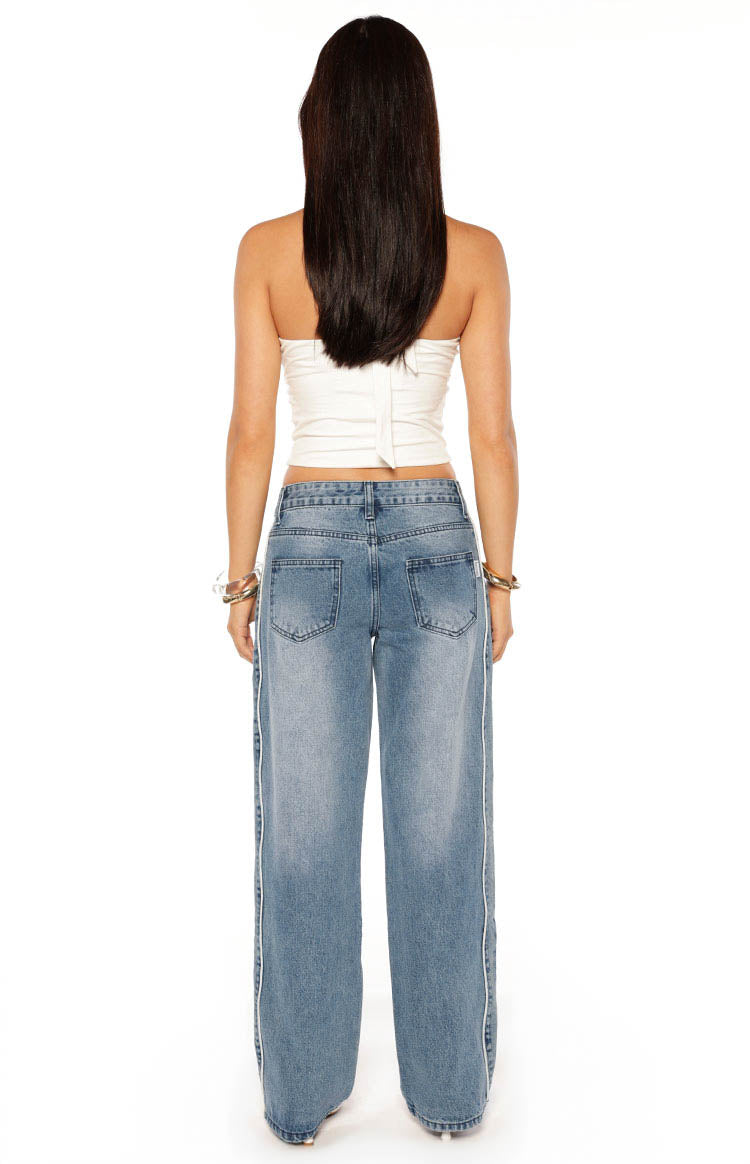 Rear view of mid wash blue wide leg jeans with contrast white side seams and back pockets