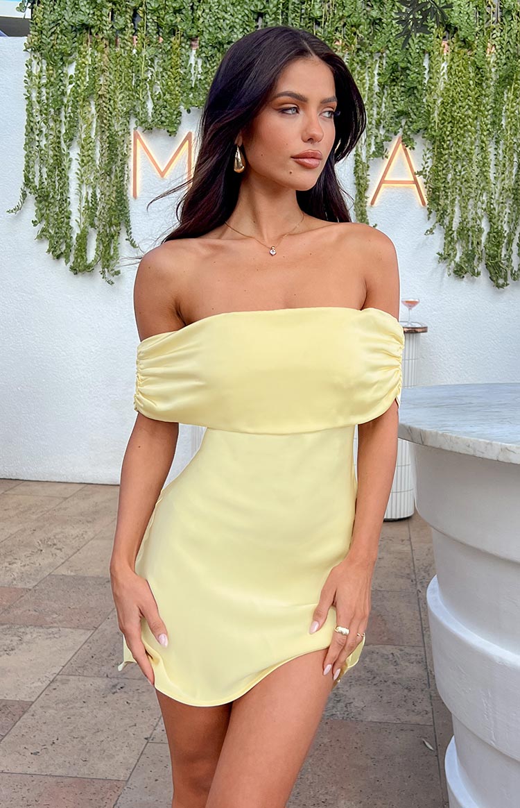 Primrose yellow satin off-the-shoulder mini dress with a draped neckline and ruched short sleeves