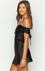Side view of a black satin off-the-shoulder mini dress with ruched sleeves and tie detail