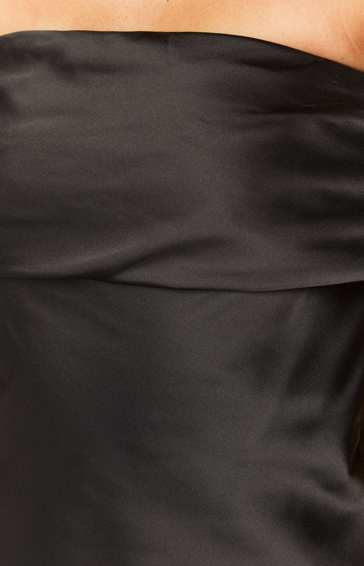 Close-up of the draped black satin fabric on the bodice of the mini dress