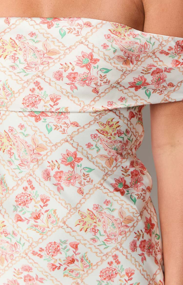 Close-up of the white off-shoulder mini dress showing the pink floral paisley pattern with chain-link lattice