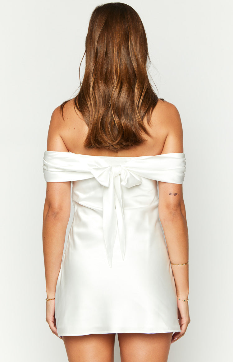 Rear view of a white satin off-the-shoulder mini dress with a large bow detail at the back