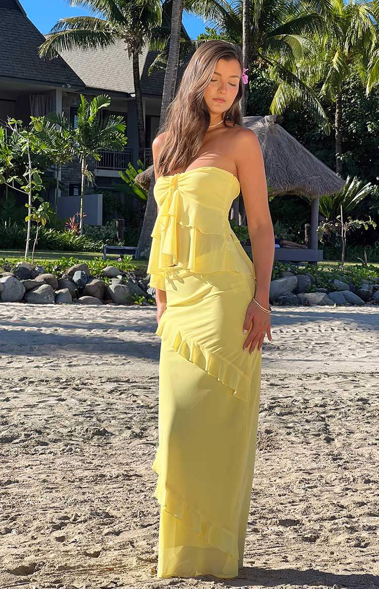 Yellow maxi skirt with diagonal tiered ruffles from hip to hem, showing flowy fabric