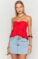 Model displays a vibrant red strapless ruffle top featuring a ruched drawstring front