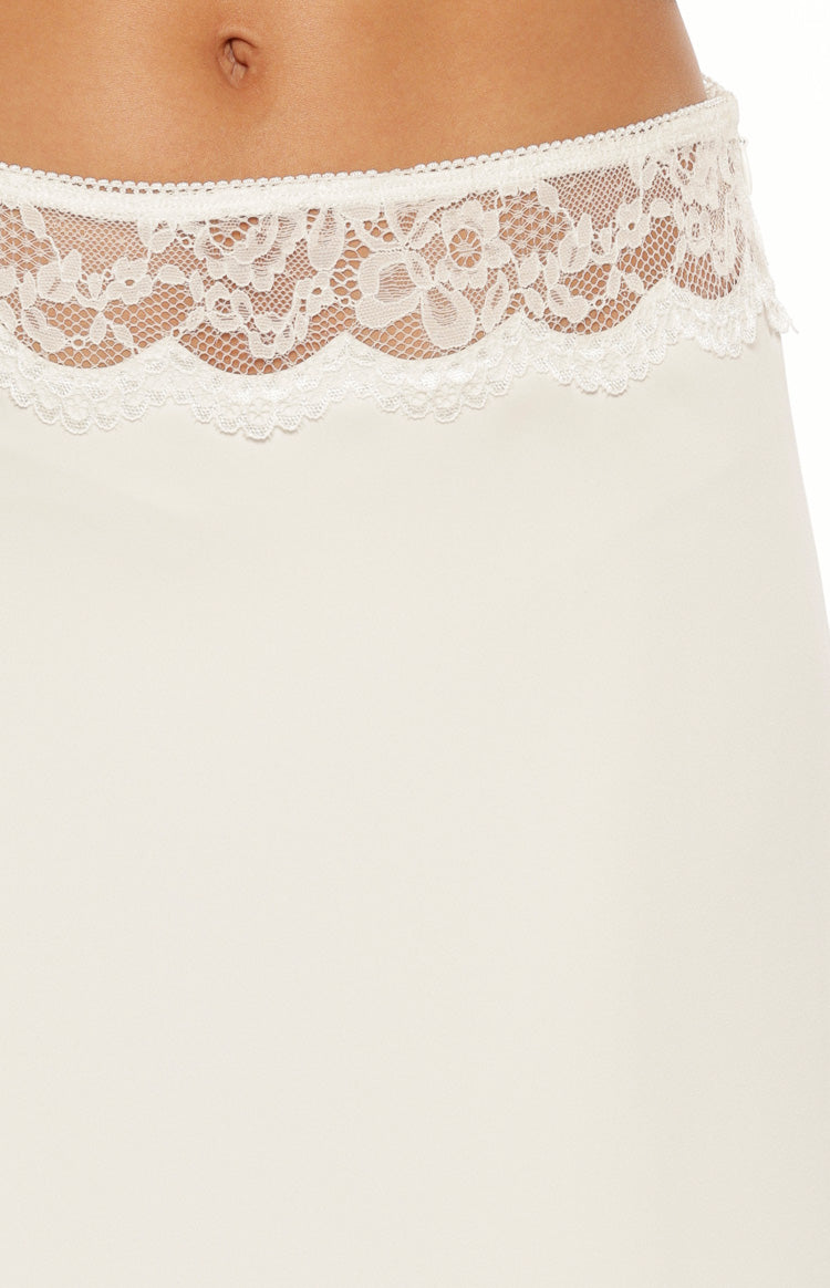 Close-up of the intricate white floral lace trim with a scalloped edge on the midi skirt waistband