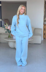 Light blue mock neck sweater with long sleeves, relaxed fit, and 'BEGINNING' applique text