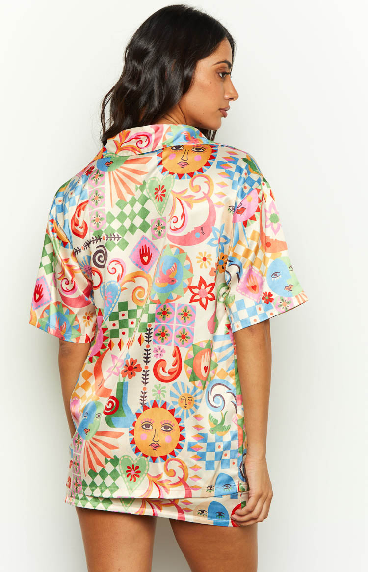 Rear view of a colourful satin shirt with a vibrant sun and moon print and short sleeves