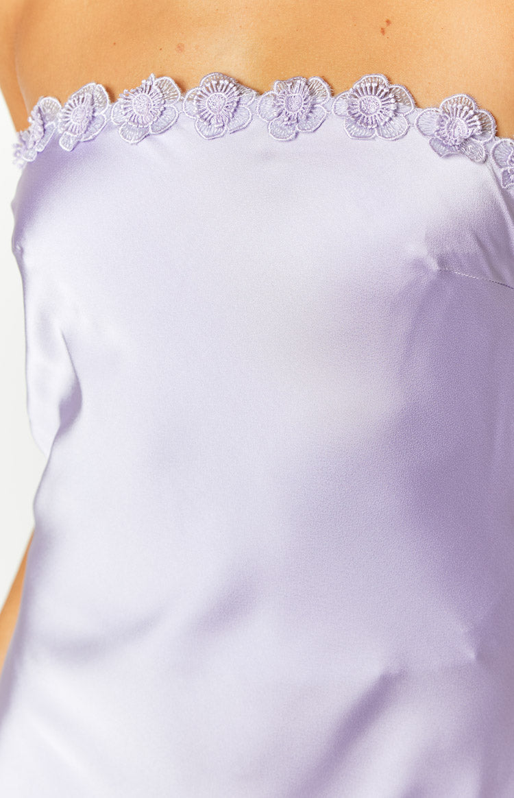 Close-up of the intricate floral lace trim along the strapless neckline of a purple satin maxi dress