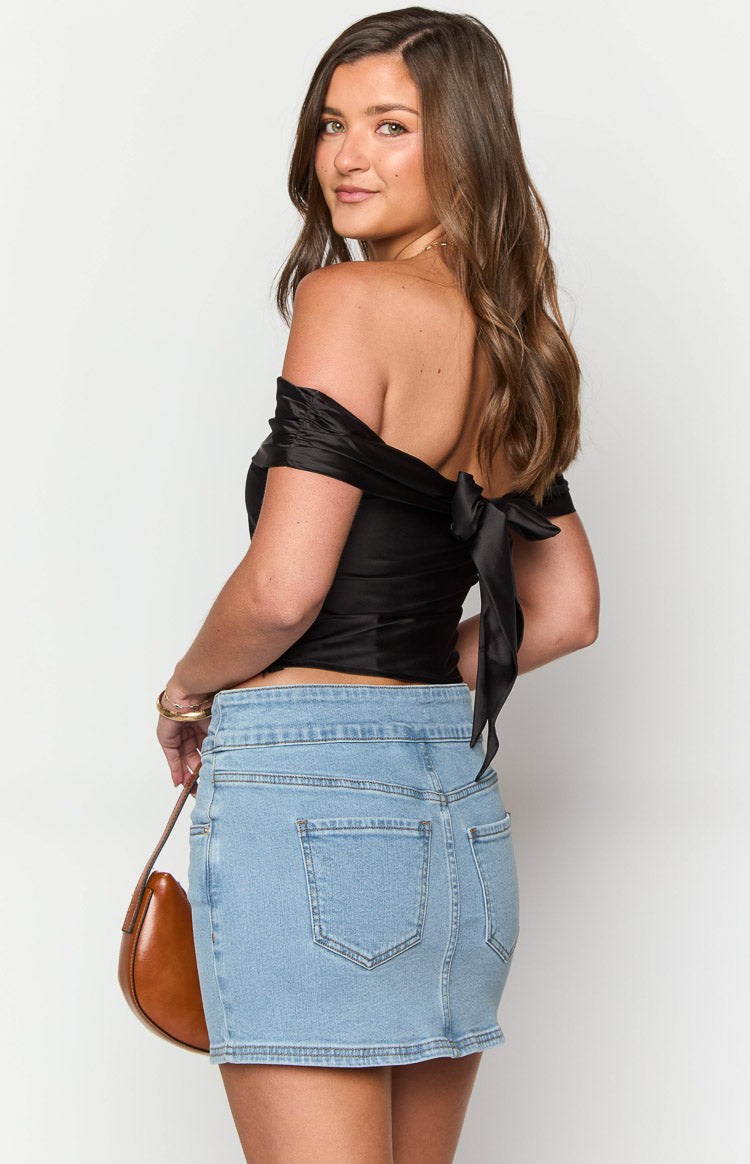 Rear view of a light wash denim mini skirt with classic back pockets