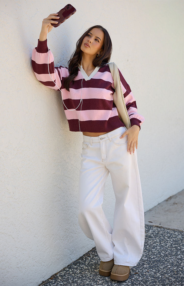 Pink and maroon striped knit polo with a V-neck and white collar detail, showing the cropped length