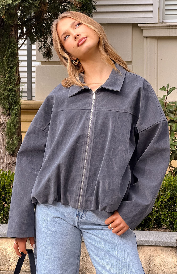 Front view of a steel grey suedette bomber jacket with a collared neckline, silver zip front, and bubble hem