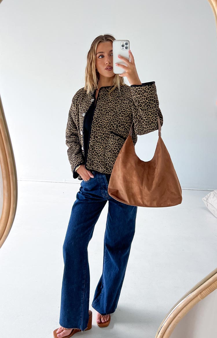 Leopard print quilted jacket with a round neckline, black trim, and silver button front