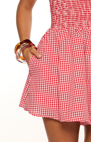 Model wearing a cute red and white gingham halter neck playsuit with a ruched bodice perfect for a Summer picnic or casual brunch
