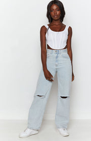 High-waisted light blue wide leg jeans with large ripped knees