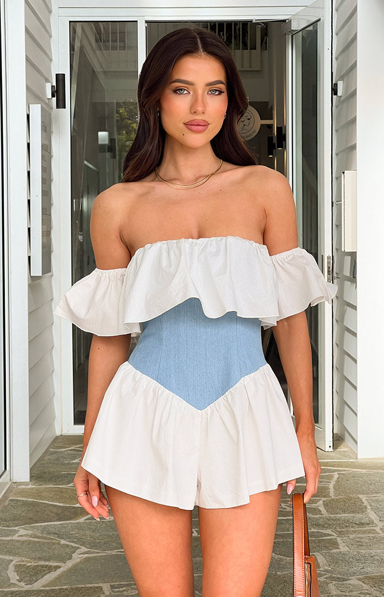 Off-shoulder white playsuit with a ruffled neckline, light blue denim corset waist, and white ruffled shorts