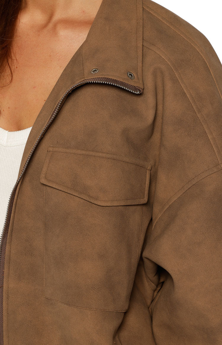 Close-up of the brown suedette jacket showing the funnel neck, zipper, snap buttons, and chest pocket