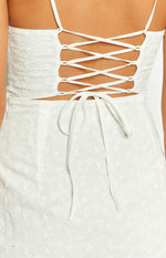 Rear close-up of the white broderie dress featuring a criss-cross lace-up back and tie detail