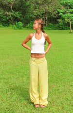 Front view of a white halter neck top with a scoop neckline and cropped hem