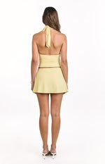 Rear view of a smooth pale yellow A-line mini skirt with a subtle flared hem