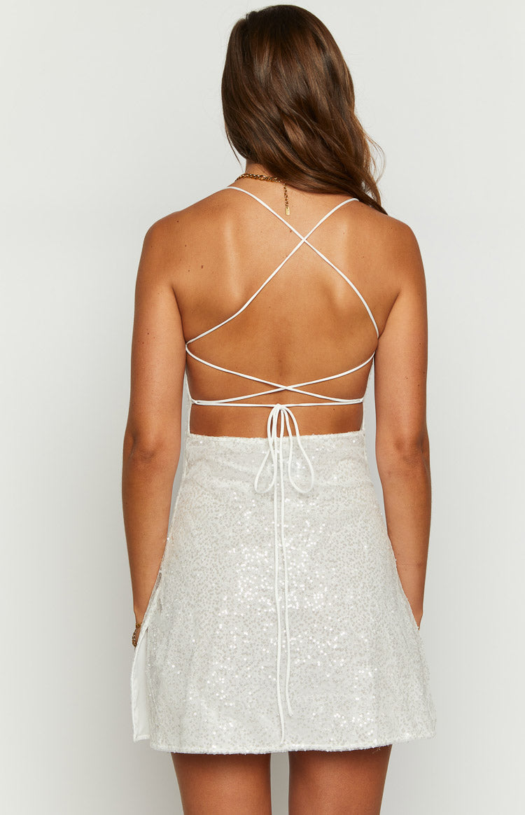 Rear view of a white beaded mini dress with criss-cross back straps, tie-back, and side slit