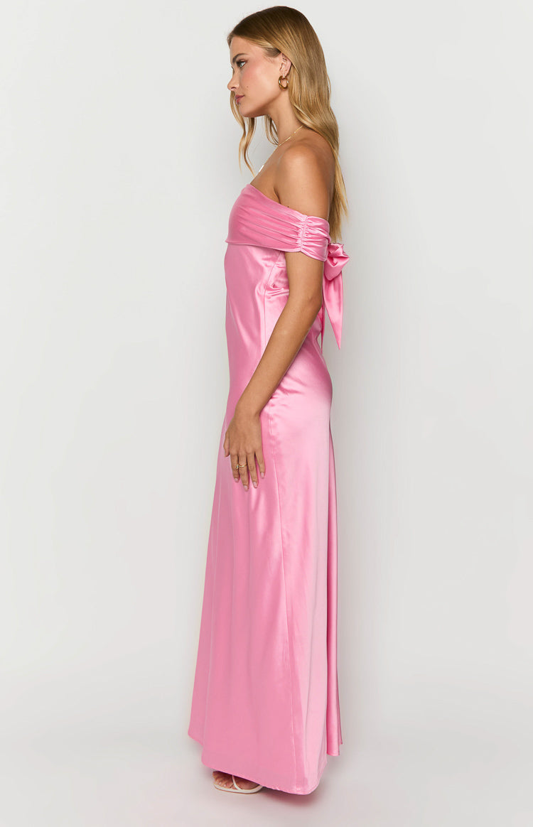 Side view of a pink satin off-shoulder maxi dress with ruched sleeves and a decorative tie on the arm