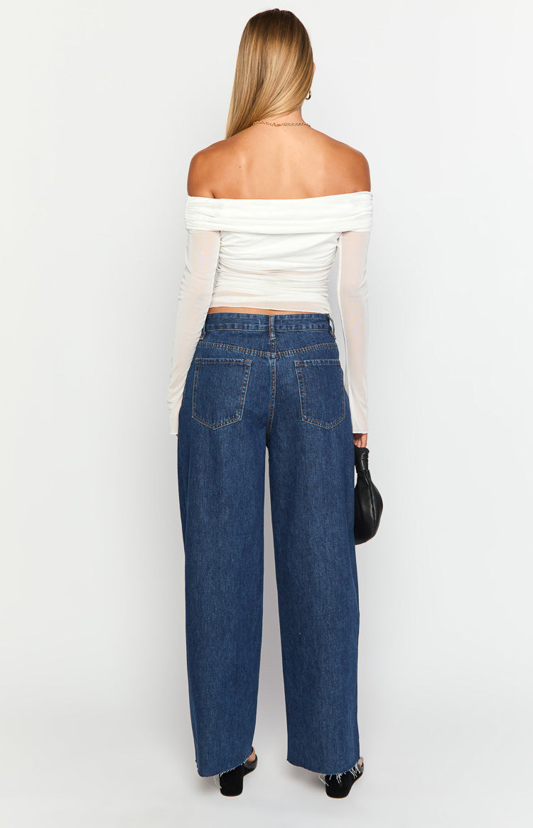 Rear view of dark wash wide leg boyfriend jeans with back pockets, yoke, and raw distressed hem
