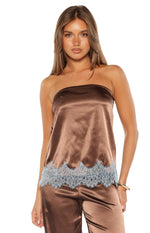Top-down view of a brown satin top featuring wide light blue lace trim along the bottom hem