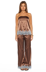 Front view of a brown satin strapless top with light blue scalloped lace trim at the hem