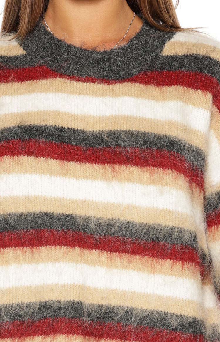 Close-up of the fuzzy multi-stripe knit sweater with red, white, beige, and grey stripes and a ribbed crew neck