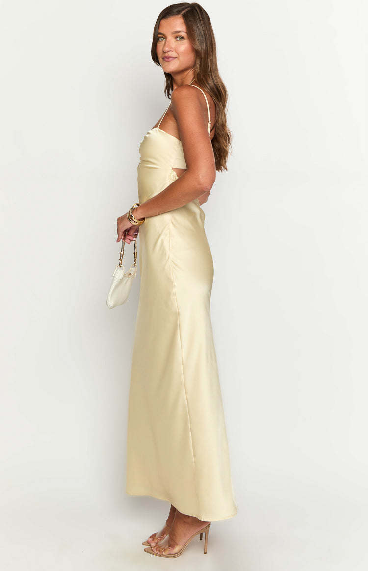 Side view of a yellow satin maxi dress showing the side cutouts with lace trim and flowy skirt