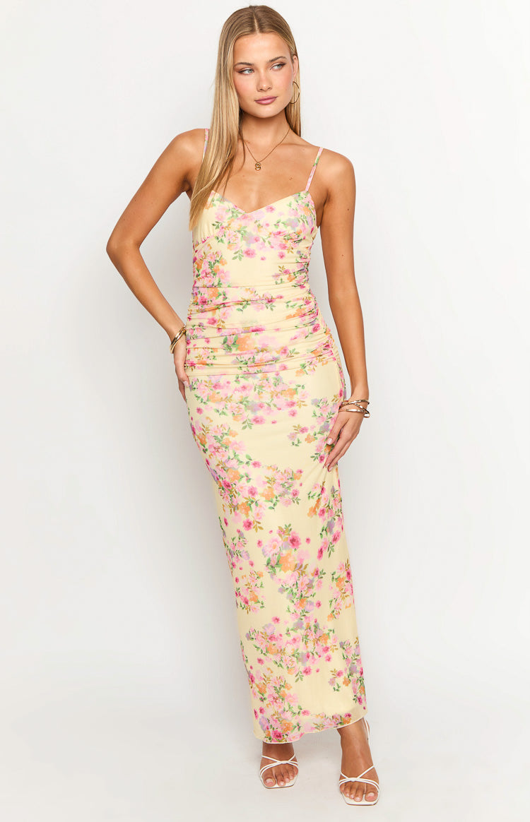 Yellow floral maxi dress with sweetheart neckline, spaghetti straps, and ruched detailing on the bodice and sides