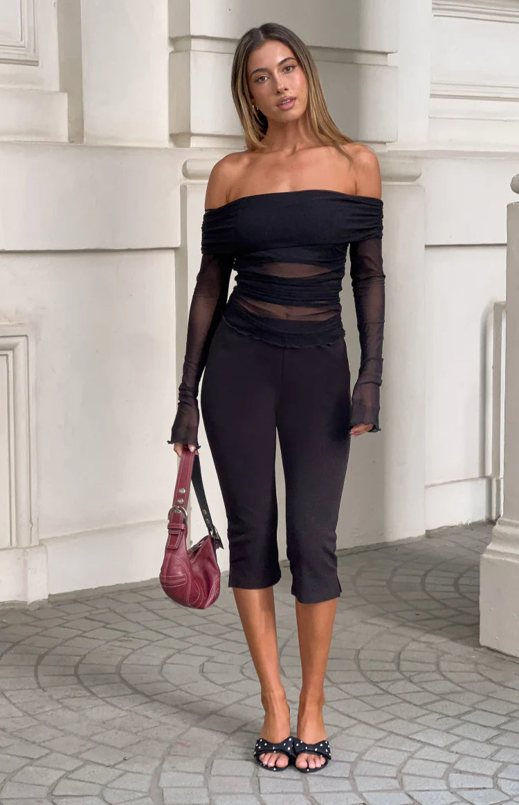 Black off shoulder top with draped neckline, sheer mesh long sleeves and midriff panels